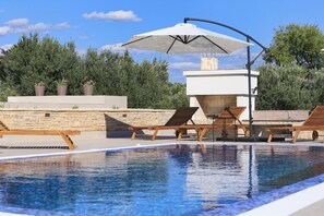 A pool area with lounge chairs and an umbrella. - Villa Capan Zadarvillas (Sveti Filip i Jakov)