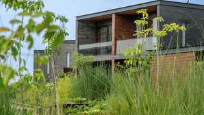 A modern building with a flat roof, large windows, and a balcony. - MYSA Zinc Journey by The Fern (A Glade One Golf Resort) Nani Devati, Gujarat  (Sanand)