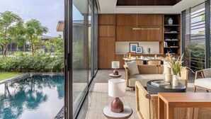 A modern interior with a pool, wooden furniture, and a kitchen area. - MYSA Zinc Journey by The Fern (A Glade One Golf Resort) Nani Devati, Gujarat  (Sanand)