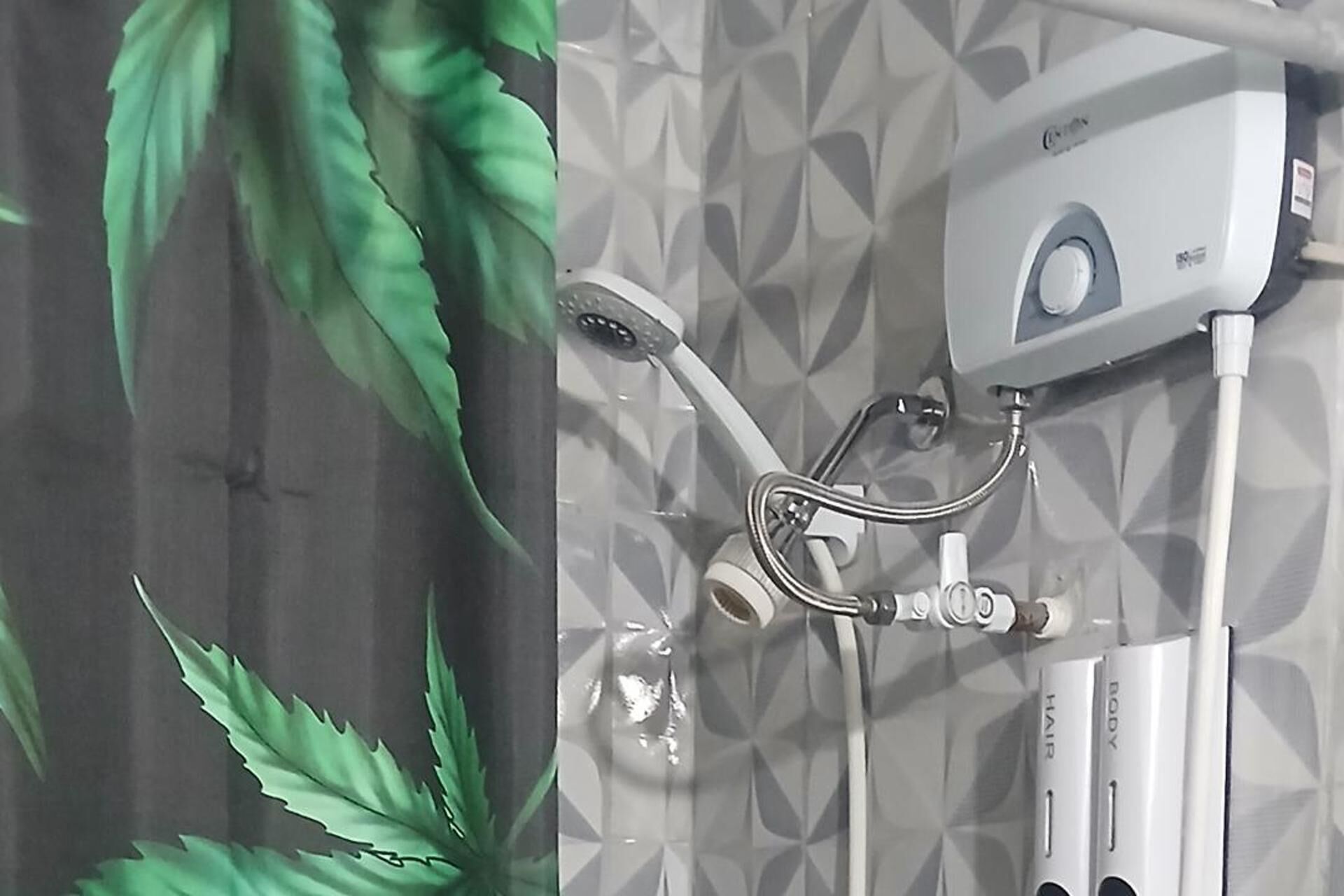 Une salle de bain avec une douche, un sèche-cheveux et un miroir.