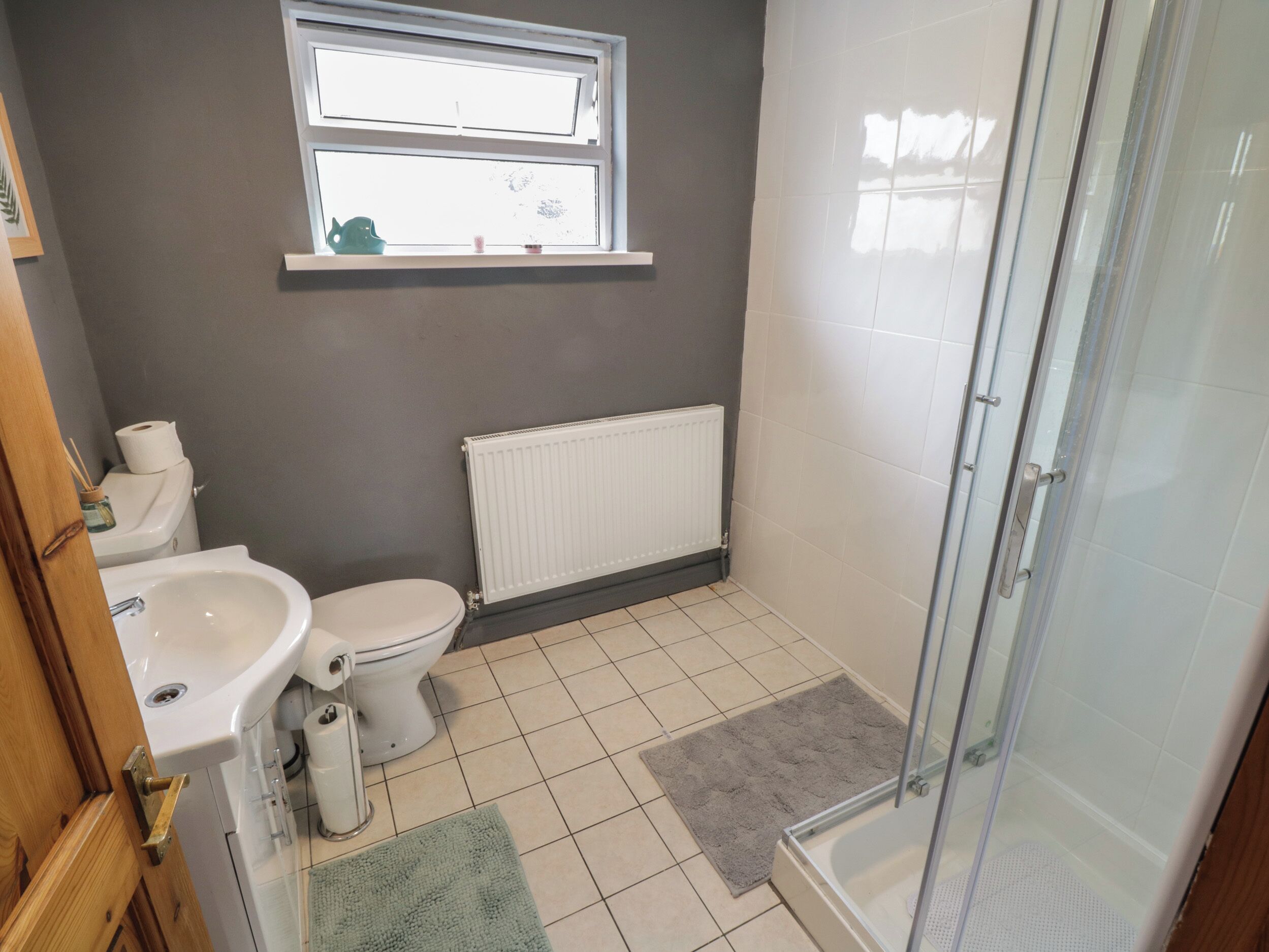 Une salle de bain avec des toilettes, un lavabo et une douche.