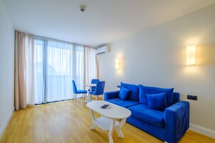 Una sala de estar moderna con un sofá azul, una mesa de centro blanca y sillas azules.