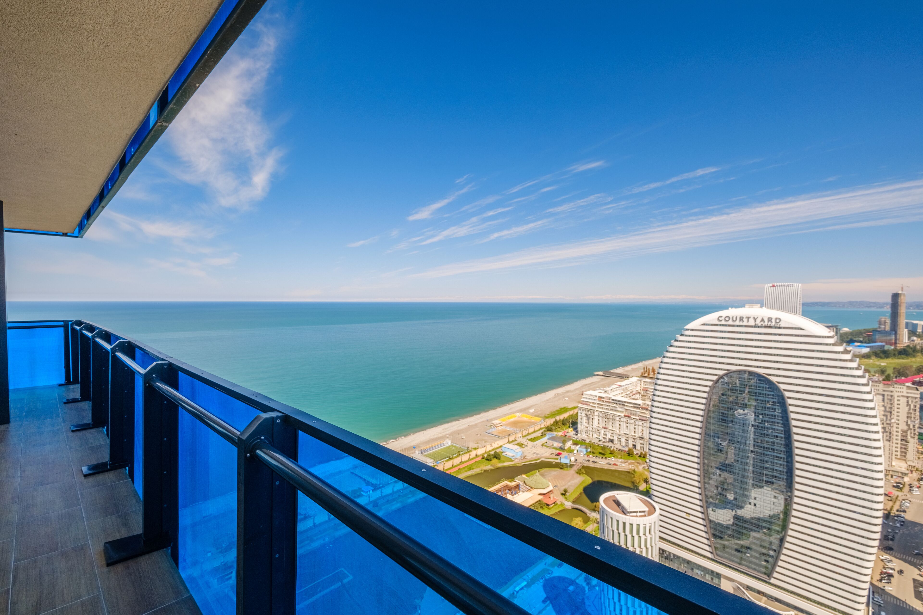 A balcony with a view of the sea and a distinctive building labeled "COURTYARD."