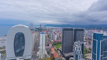 A cityscape with a prominent Courtyard by Marriott hotel, surrounded by high-rise buildings and a body of water in the background.
