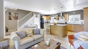 A modern living room with a sofa, coffee table, and a dining area with chairs.