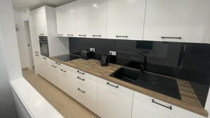A modern kitchen with white cabinetry, a black countertop, and a built-in oven. - 2 Bedroom Villa With Heated Pool (Torre-Pacheco)