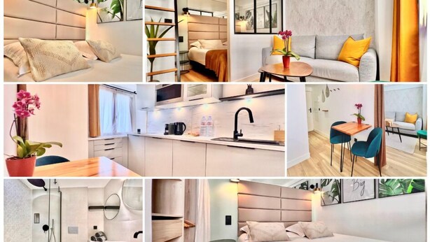 Una habitación de hotel moderna con cama, mesita de noche y un pequeño rincón de estar con sofá y sillones.