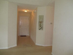 Leading to an entrance, this hallway features a light fixture and artwork.
