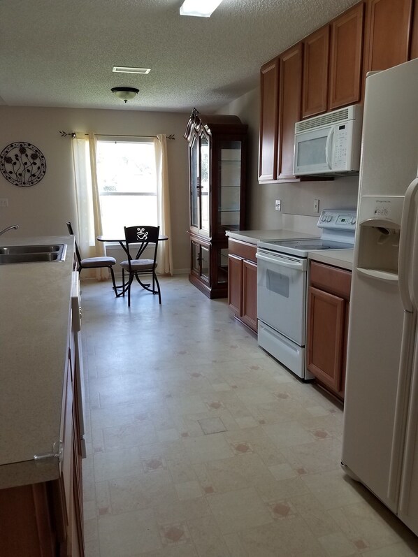 Enjoy cooking and dining in this well-equipped kitchen with a stove, microwave, and refrigerator.