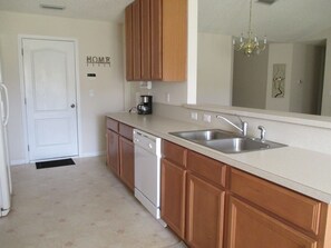 kitchen with a large mirror, chandelier, and modern appliances.