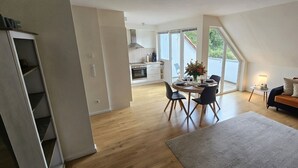 Eine moderne Wohnung mit Essbereich, Küche und Wohnzimmer.