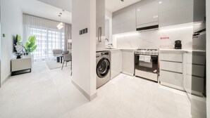 A modern kitchen with a washing machine, oven, and refrigerator. - Polished 1BR at Binghatti Creek Al Jadaf by Deluxe Holiday Homes (Dubai)