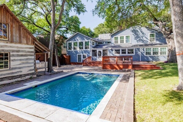 Enjoy a refreshing swim in the backyard pool surrounded by a deck and lawn.