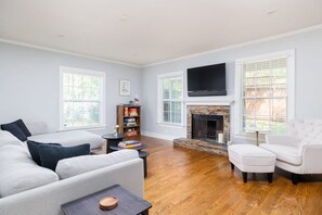 Relax in this cozy living space with a large TV, stone fireplace, and comfortable seating area.