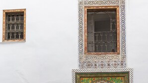 A traditional Moroccan architectural entrance with intricate tile work, a wooden door, and a staircase leading to an upper level. - Riad 9 Fez  (Fes)
