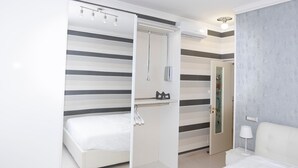 Une chambre d’hôtel moderne équipée d’un lit, d’une table de chevet, d’un miroir et d’une petite table.