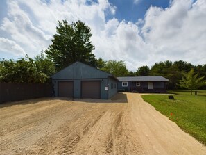 A two-story building with a blue roof and a fenced driveway.