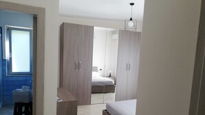 A bedroom with a bed, wardrobe, and a desk. - 20 min from Pompeii and 35 min from Amalfi, structure surrounded by greenery (Campania)