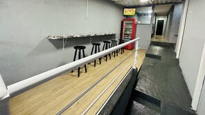A corridor with a bar area featuring stools and a red beverage dispenser. - On Hostel gru unidade 2 traslado café  (Guarulhos)