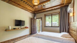 A bedroom with two beds, a TV on the wall, a window with curtains, and a wooden ceiling. - Ziyan Shanju Inn (Deqing)