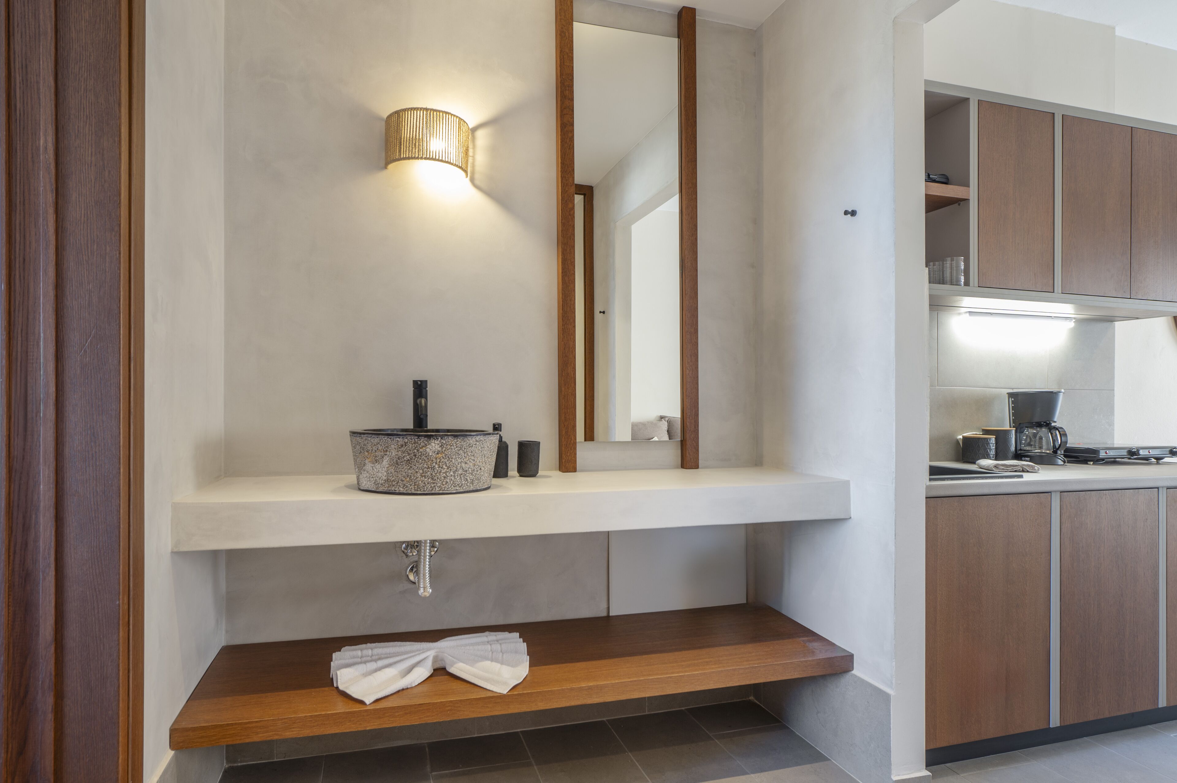 A modern bathroom with a wooden vanity, a large mirror, and a built-in sink.