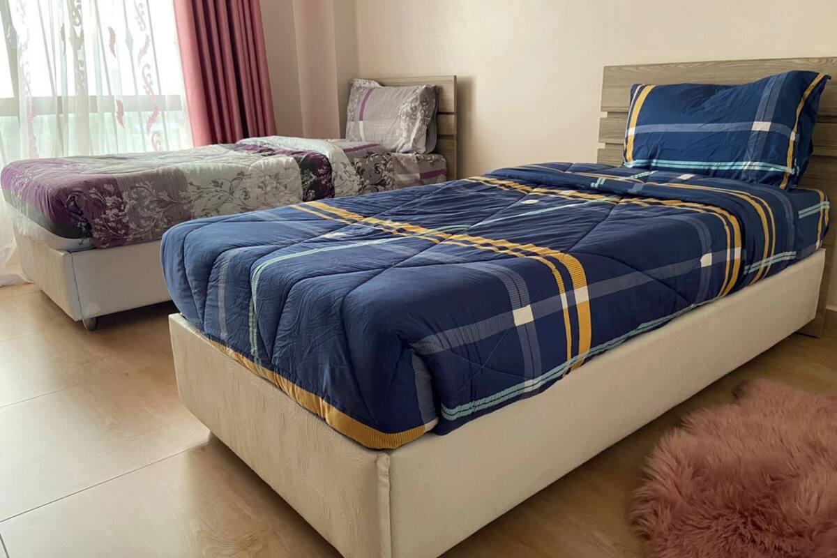 Un dormitorio con una cama grande, un sofá cama más pequeño y una alfombra mullida.