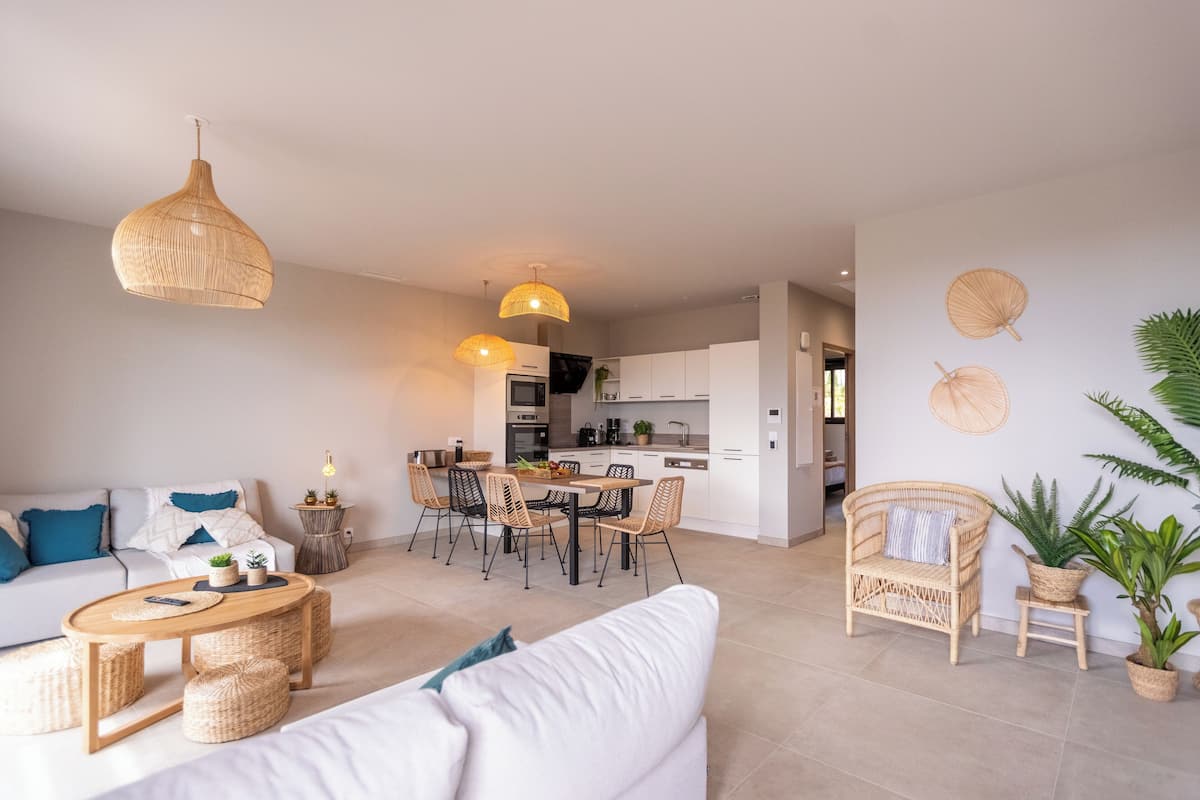 Uma sala de estar moderna com sofá, mesa de centro e área de jantar.