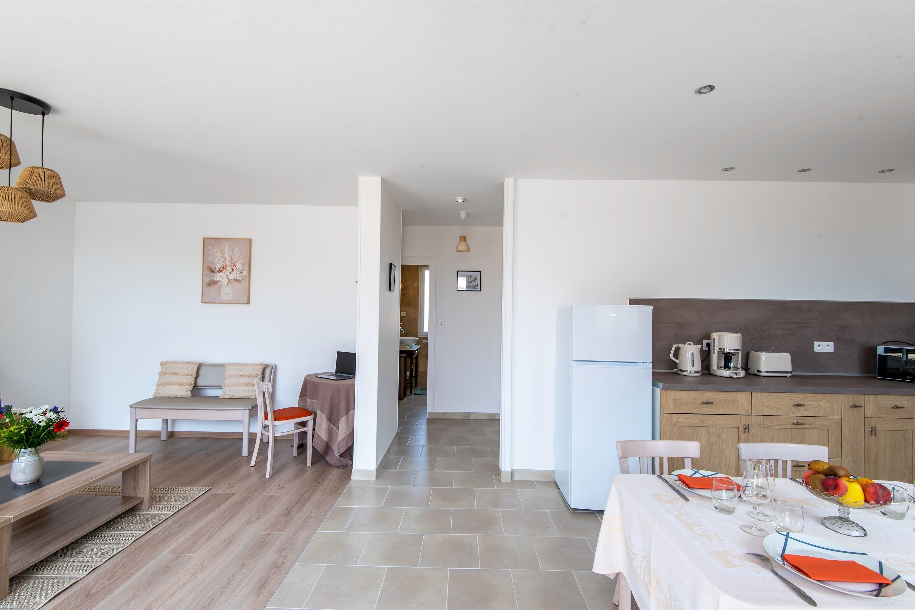 Una cocina moderna con comedor, un sofá y una cafetera.
