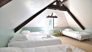 A room with two beds, a small table, and a window with a view. - Mézange Bleue - Près du canal d'Ille et Rance (Lanvallay)