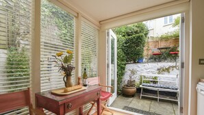 Une pièce avec une table en bois, une chaise et une plante en pot.