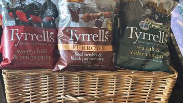 Una cesta de mimbre llena con diferentes bolsas de patatas fritas Tynrell's.