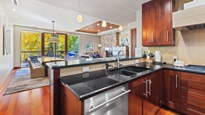 A modern kitchen with a large island, stainless steel appliances, and wooden cabinets. - Grand Hyatt|The charismatic and stylish townhome boasting immaculate views (Vail)
