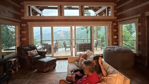 Un salón amplio con techo alto, ventanas grandes y vistas al exterior.