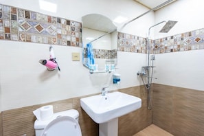 A bathroom with a white sink, a toilet, a shower, and a mirror. - Damla Hotel Baku (Baku)