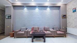 A living room with a sofa set, a coffee table, and a textured wall.