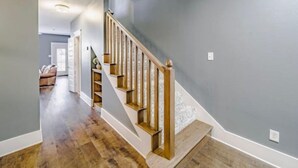 A staircase with wooden steps and a handrail, leading to a landing with a door.
