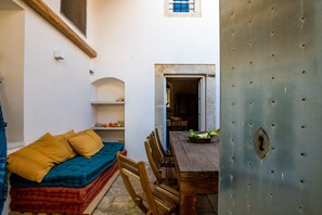 A cozy room with a wooden bed, a dining table, and a metal door.