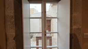 A doorway with a stone archway leading to an outdoor patio area with a wooden table and chairs. - House with direct sea access in Sampieri with 3 bedrooms (Sampieri)