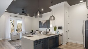 A modern kitchen with a central island, dark cabinets, and pendant lighting. - 2 Bedroom, Main Level- ADA Accessible (Helena)