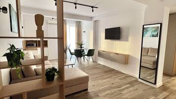 Deluxe-Apartment, Nichtraucher, Stadtblick | Wohnbereich | 108-cm-Flachbildfernseher mit Digitalempfang, Fernseher, Smart Speakers