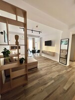 Apartamento luxo, para não fumantes, vista para a cidade | Área de estar | TV de tela plana 108 cm com canais digitais, TV, smart speakers