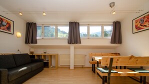 Ein Zimmer mit einer Couch, einer Holzbank, einem Tisch und einer Heizung.