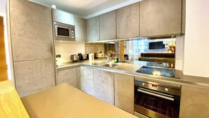 A modern kitchen with a built-in oven, microwave, and stainless steel appliances. - Stunning Little House on Poole Quay -Free Parking (Poole)