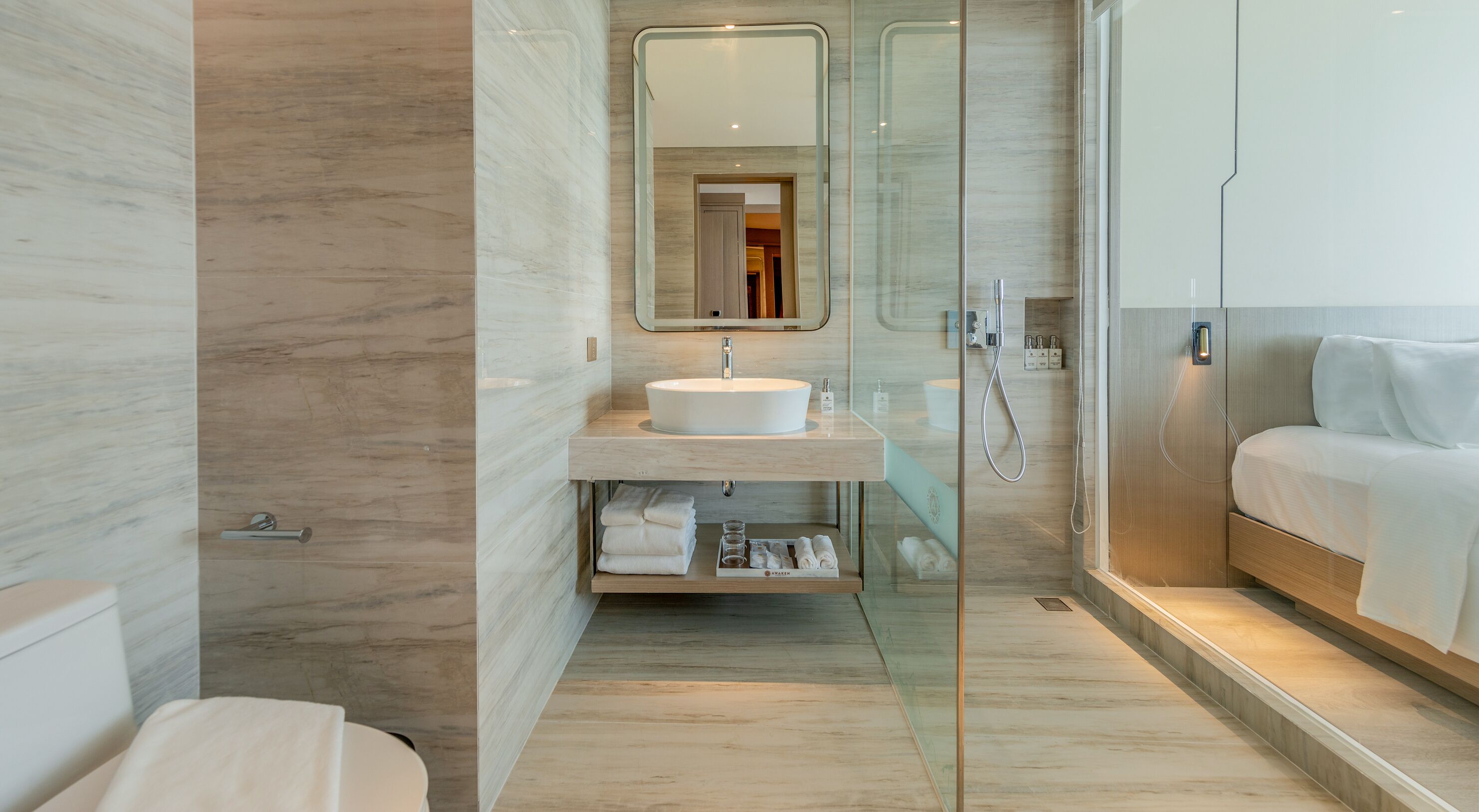 A modern bathroom with a glass-enclosed shower, a white sink, and a wooden vanity.