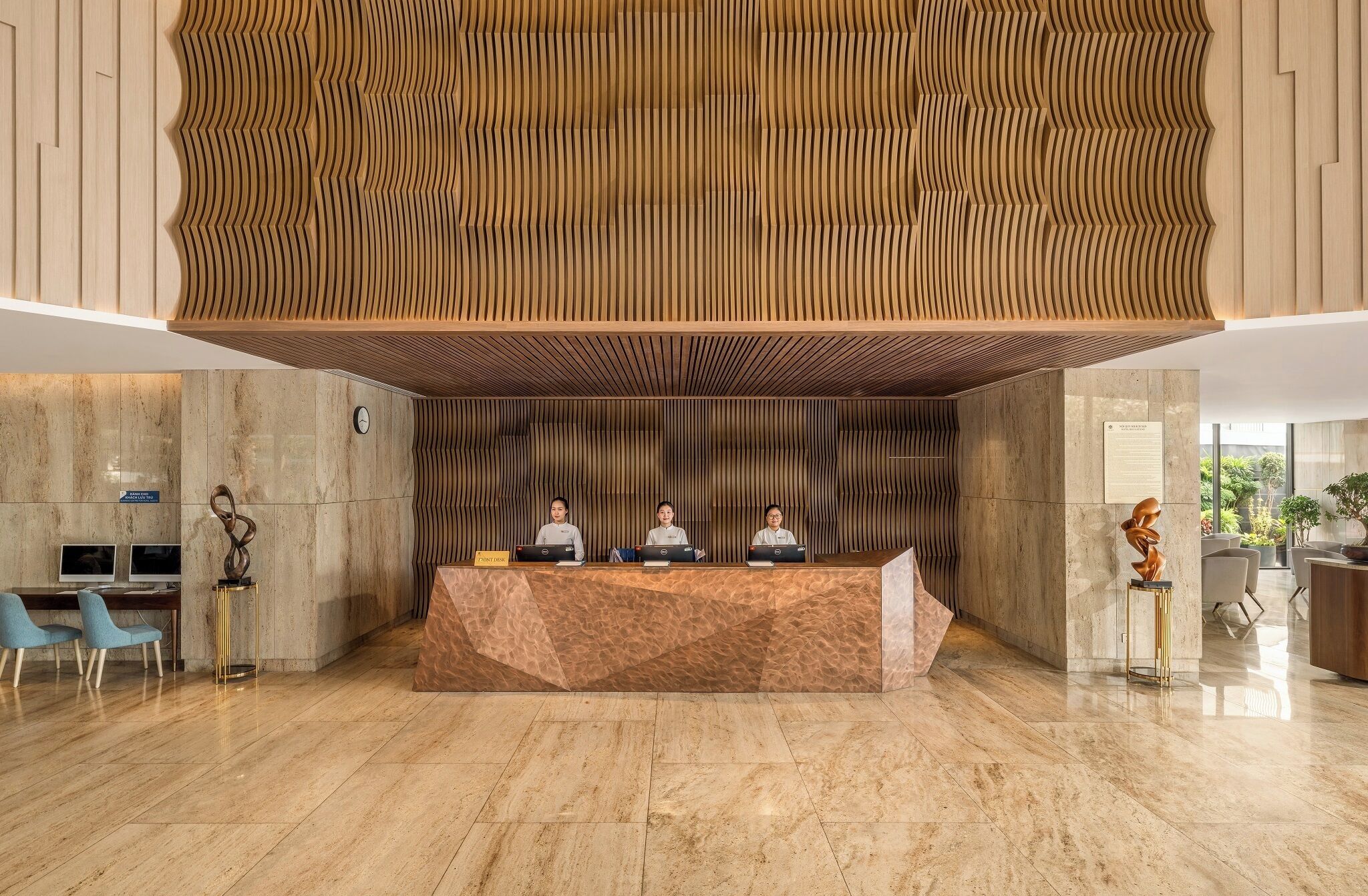 A reception desk with three staff members, a clock, and a sign indicating a point of sale.