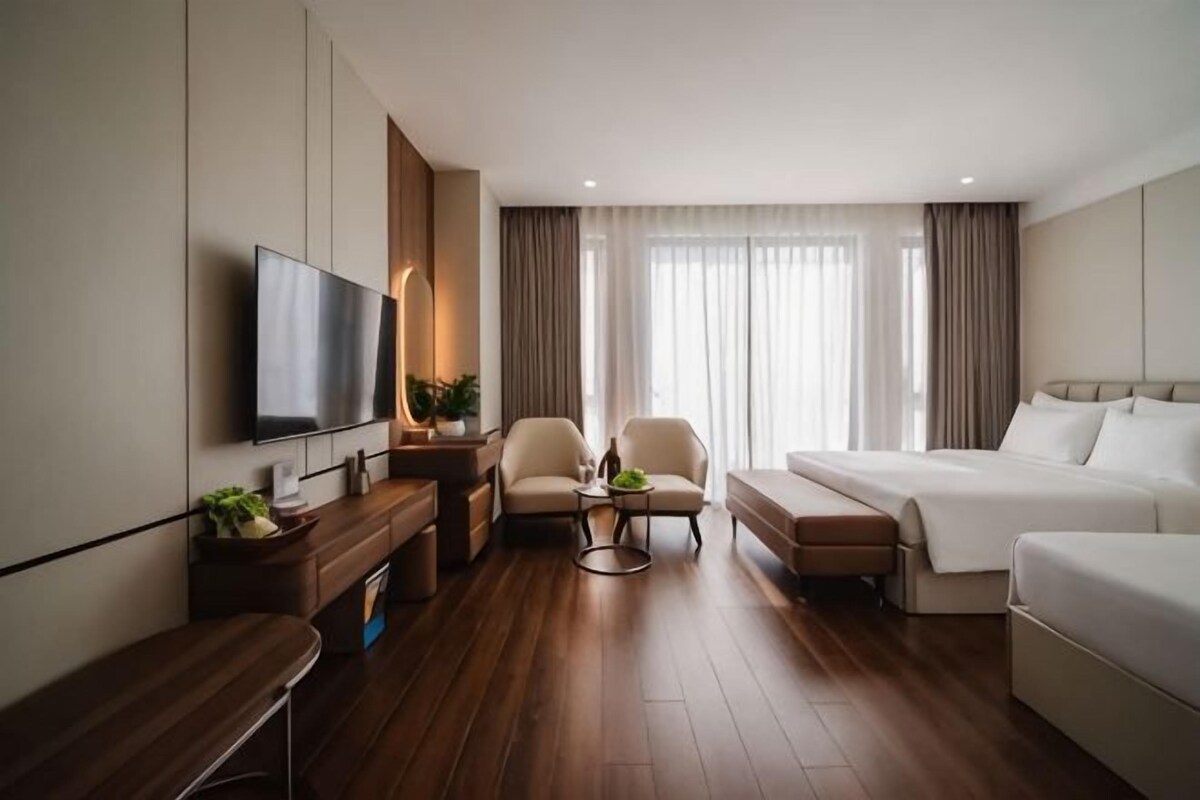 Een hotelkamer met een bed, een televisie, een bureau, een stoel en een bank.