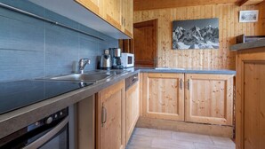 Una cocina moderna con armarios de madera, un lavamanos de acero inoxidable y un horno empotrado.