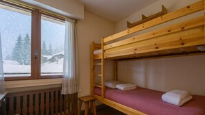 Habitación con literas y ventana con vista a un paisaje nevado.