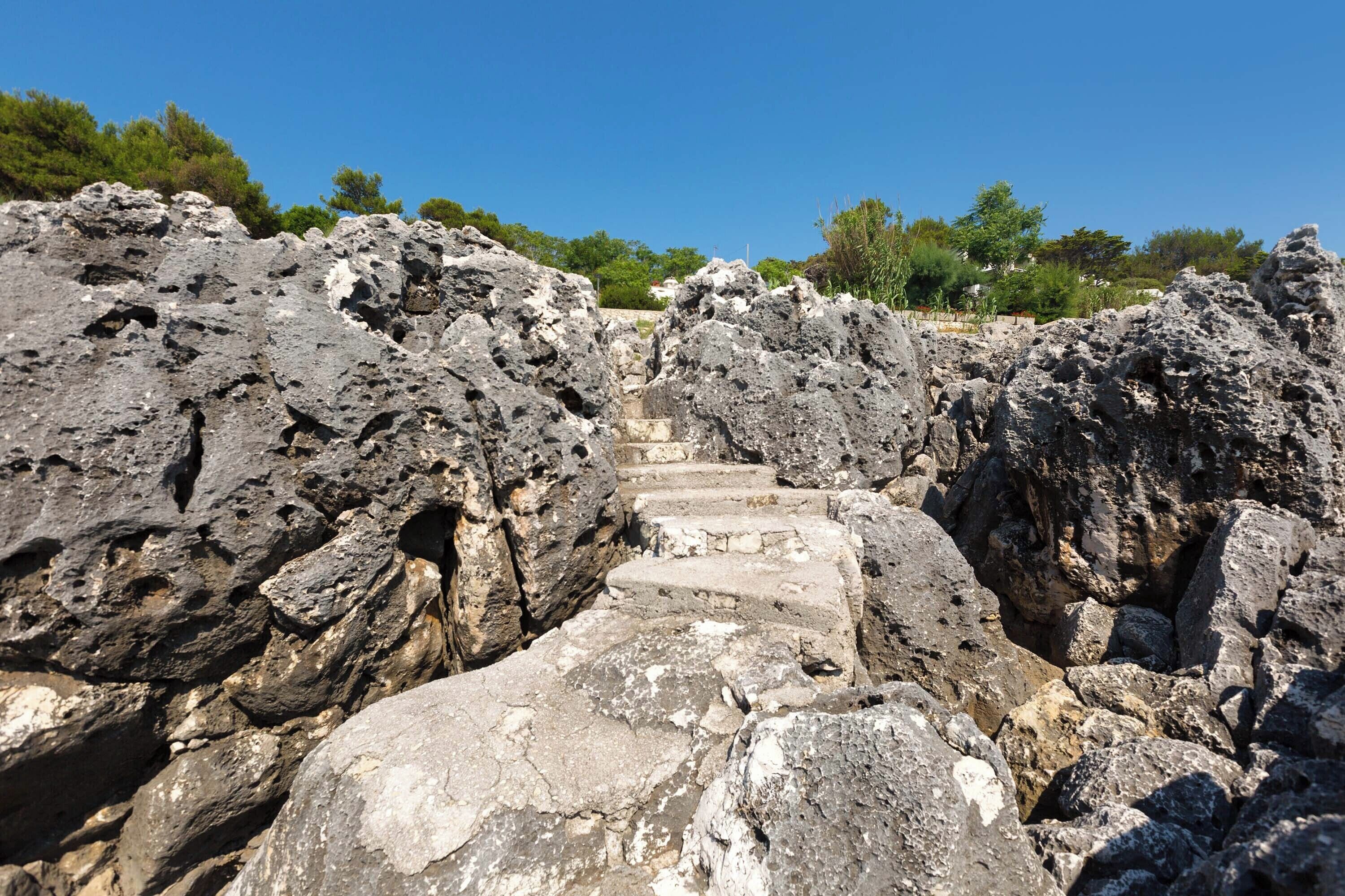 Eine steile Steintreppe, die über felsiges Gelände führt.