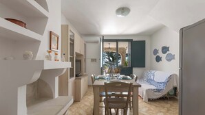 A dining area with a table set for four, a sofa, and a view of the outdoors. - Affaccio Calipso - PT by BarbarHouse (Marittima)
